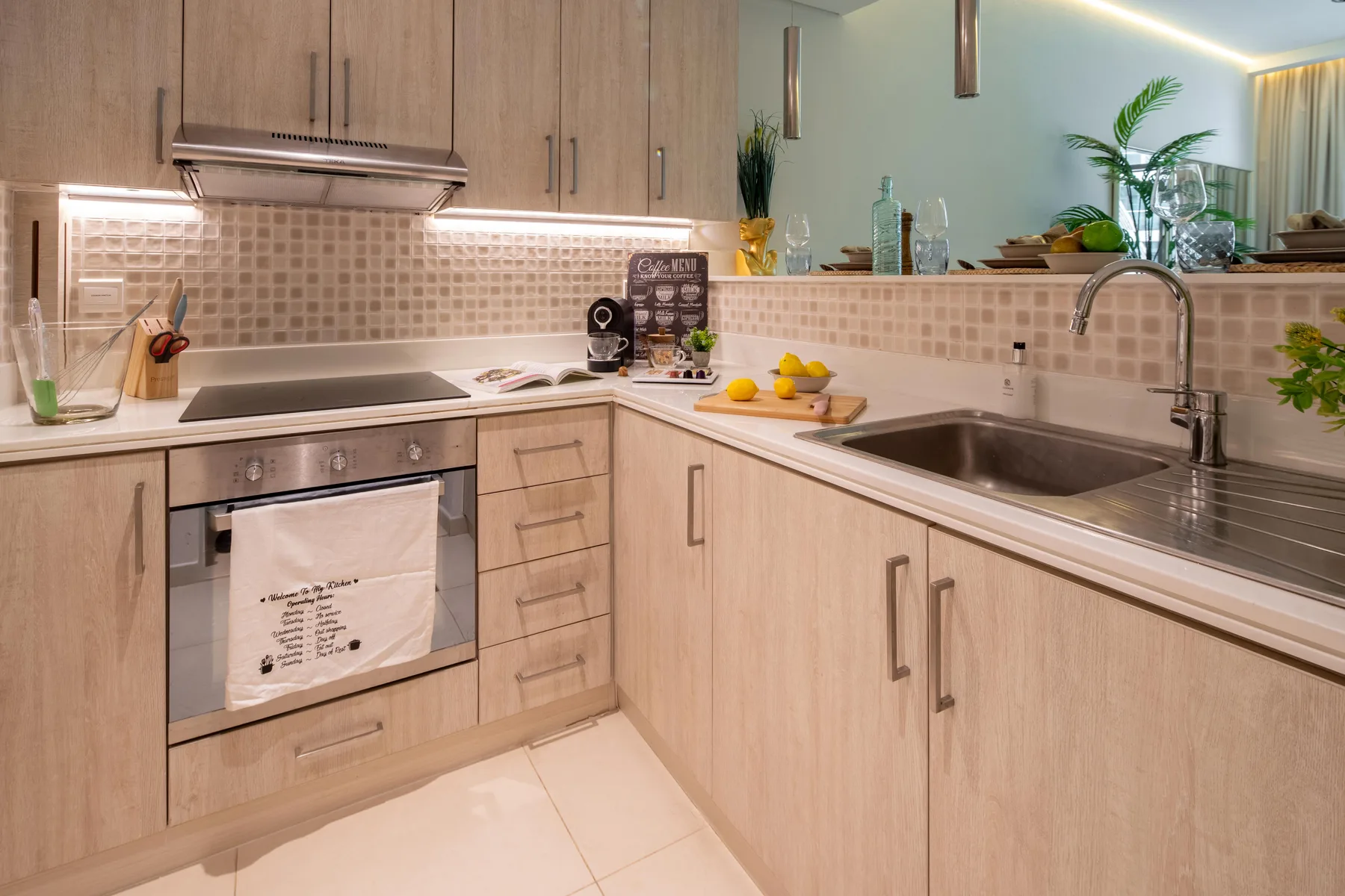 A bright kitchen with light wood cabinetry, countertops, and a sink.