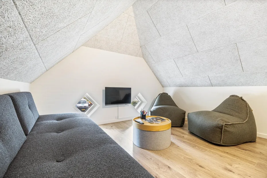 A cozy lounge area with low seating, a television, and a round coffee table.