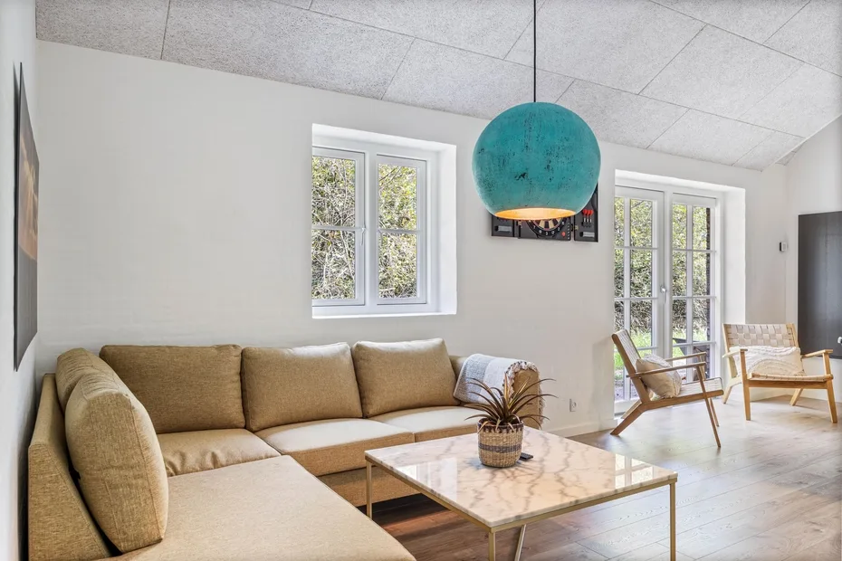 A bright living room has a sectional seating area and a low coffee table.