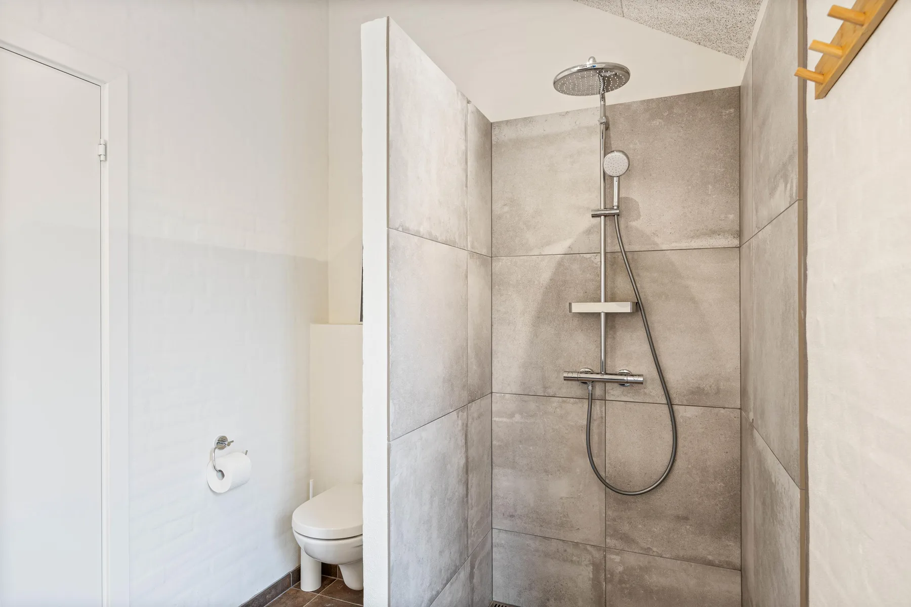 A tiled bathroom with a shower and toilet.