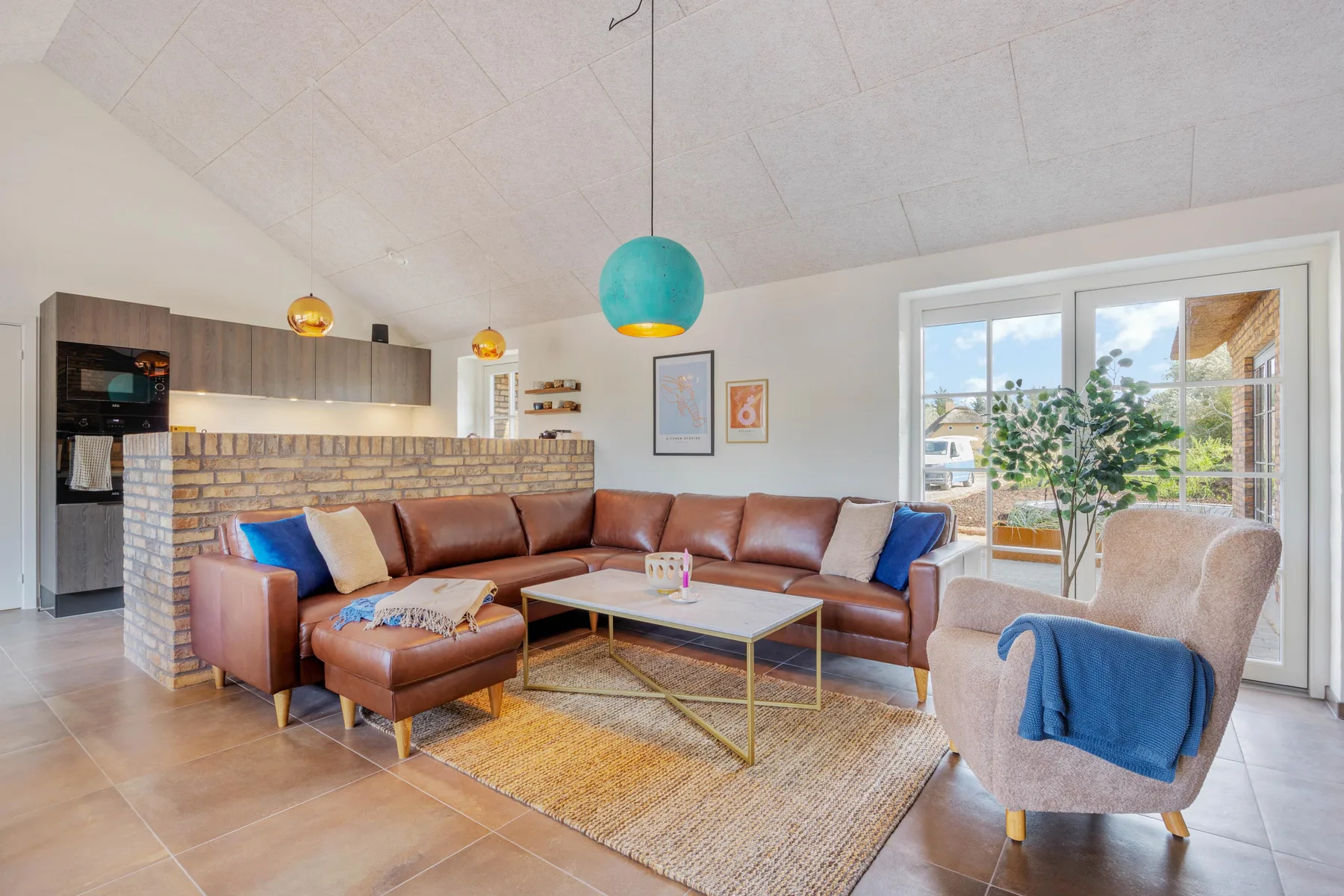 A living room with a brown sectional sofa, a coffee table, and large windows.