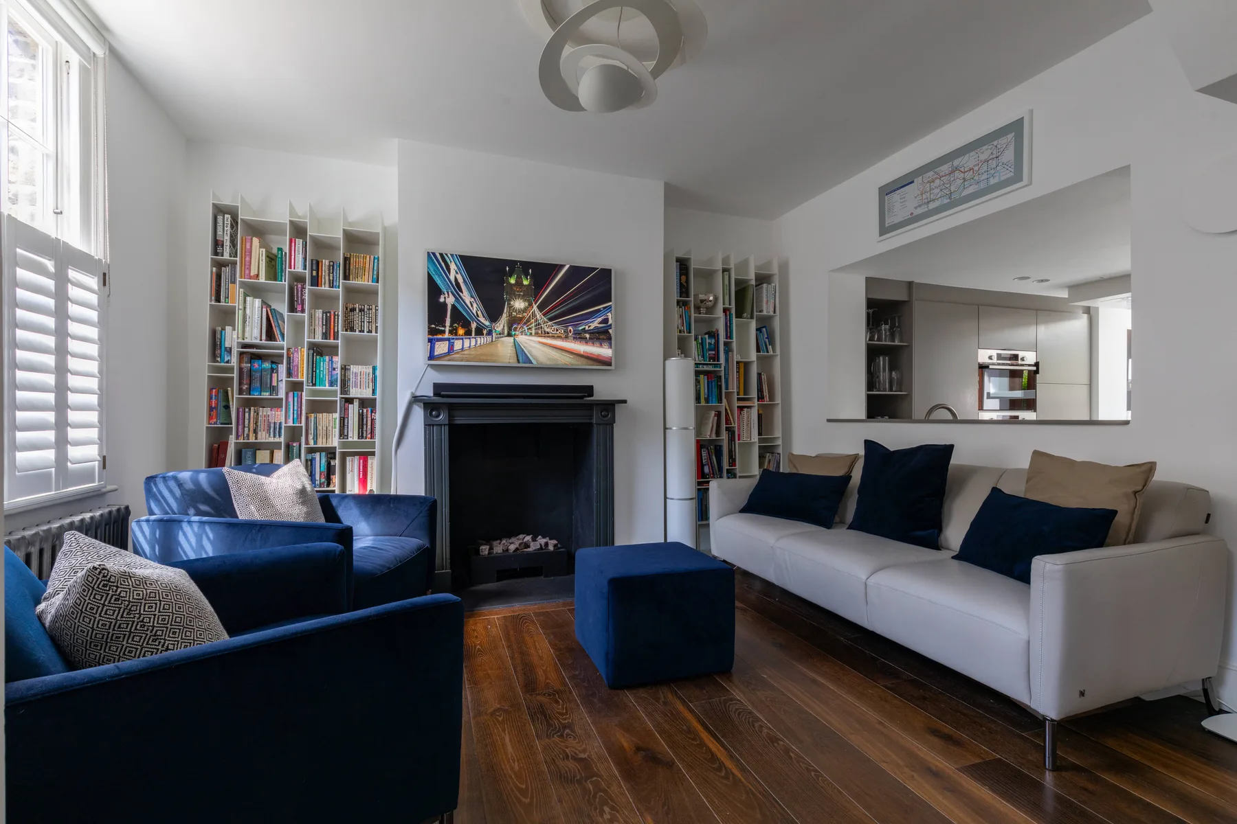A living room with seating arranged around a fireplace and television.