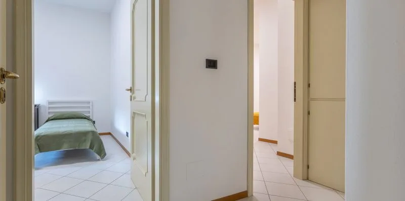 Un pasillo da a un dormitorio con una cama individual.