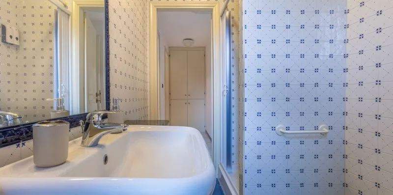 Un baño con azulejos, bañera, lavabo y zona de ducha.