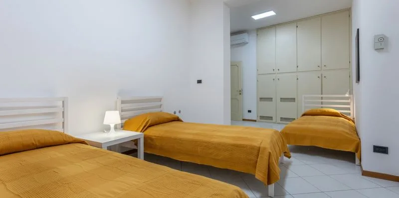 Un dormitorio con camas y armarios empotrados en la pared del fondo.