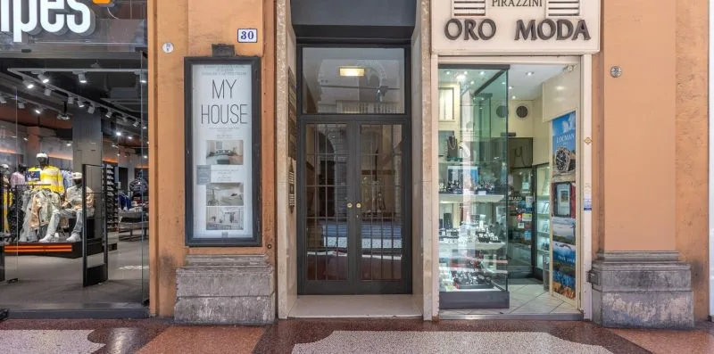 Un local a pie de calle muestra una entrada de vidrio entre dos escaparates.