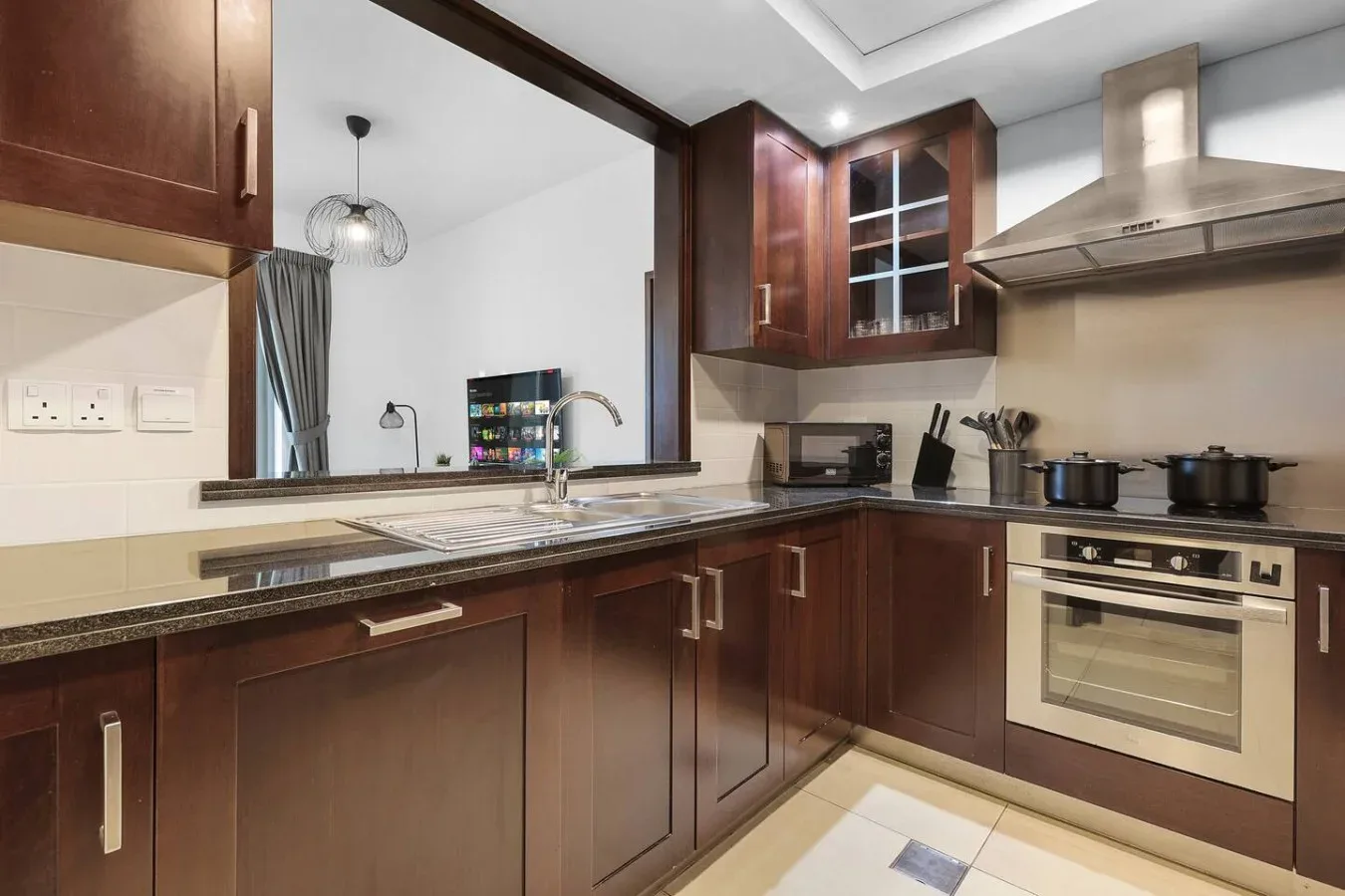 Una cocina moderna con armarios de madera oscura, una encimera y electrodomésticos integrados.