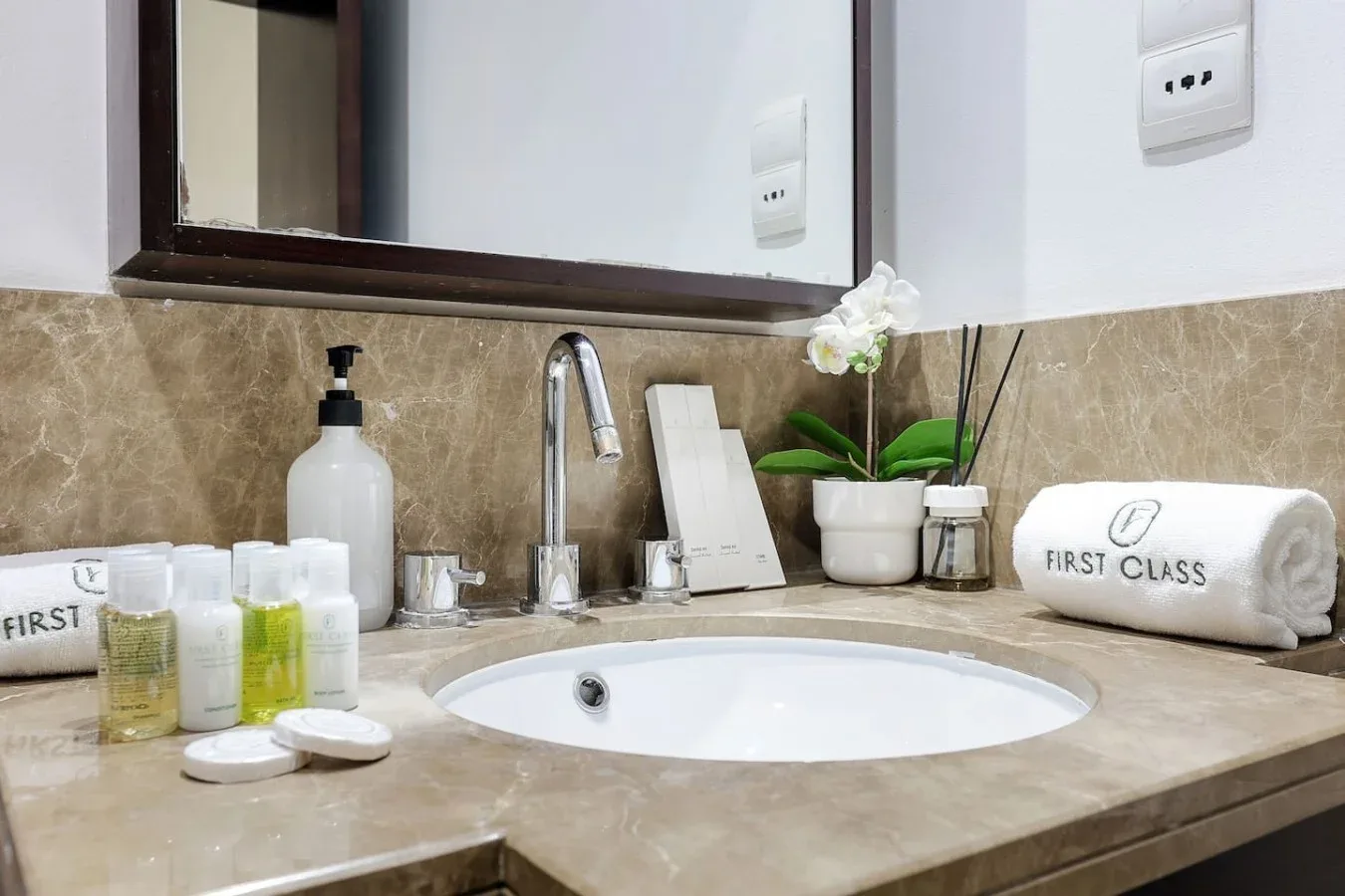 Un lavabo de baño con fregadero empotrado, grifo y artículos de aseo sobre la encimera.