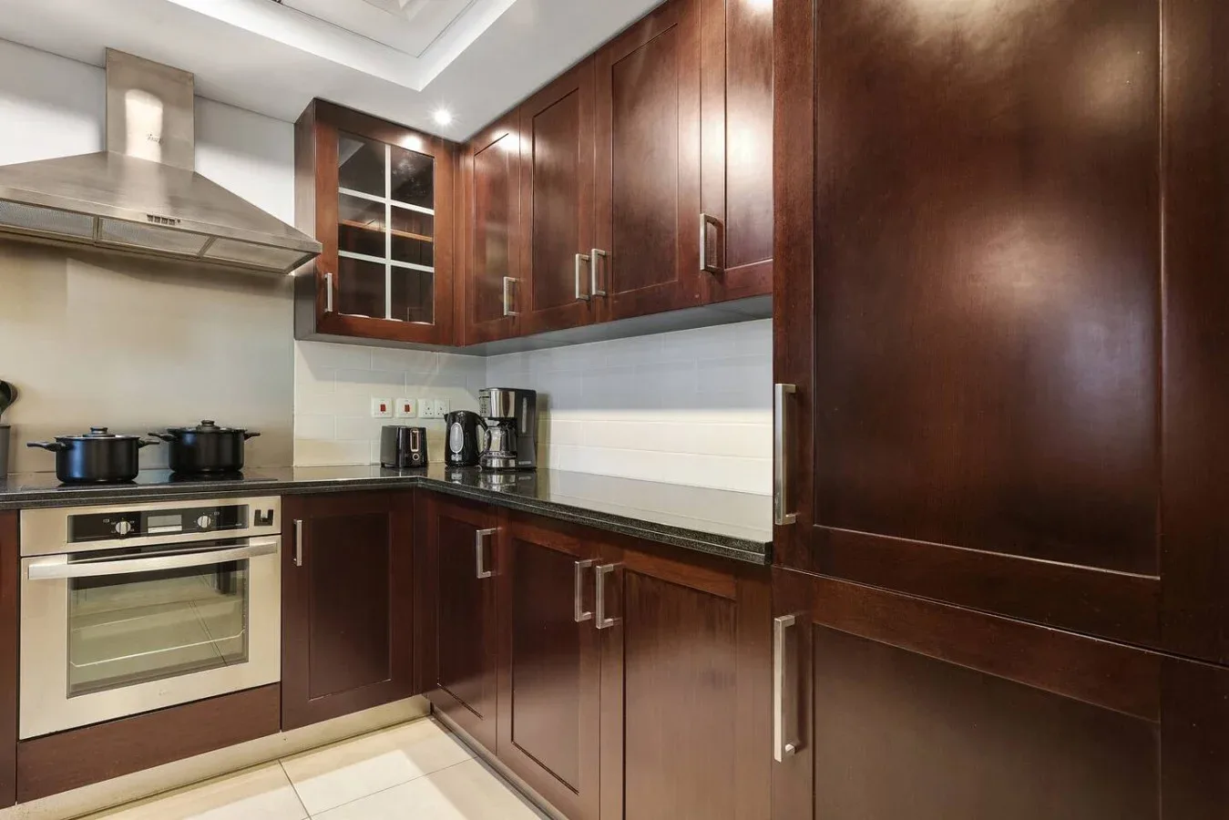 Una cocina con gabinetes de madera oscura, una estufa y un horno.