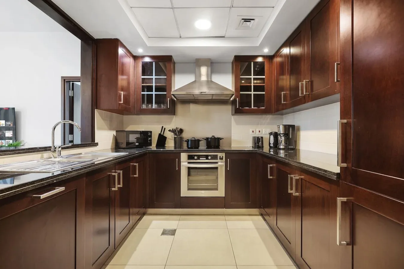 Una cocina con gabinetes de madera oscura, un horno central y encimeras a ambos lados.