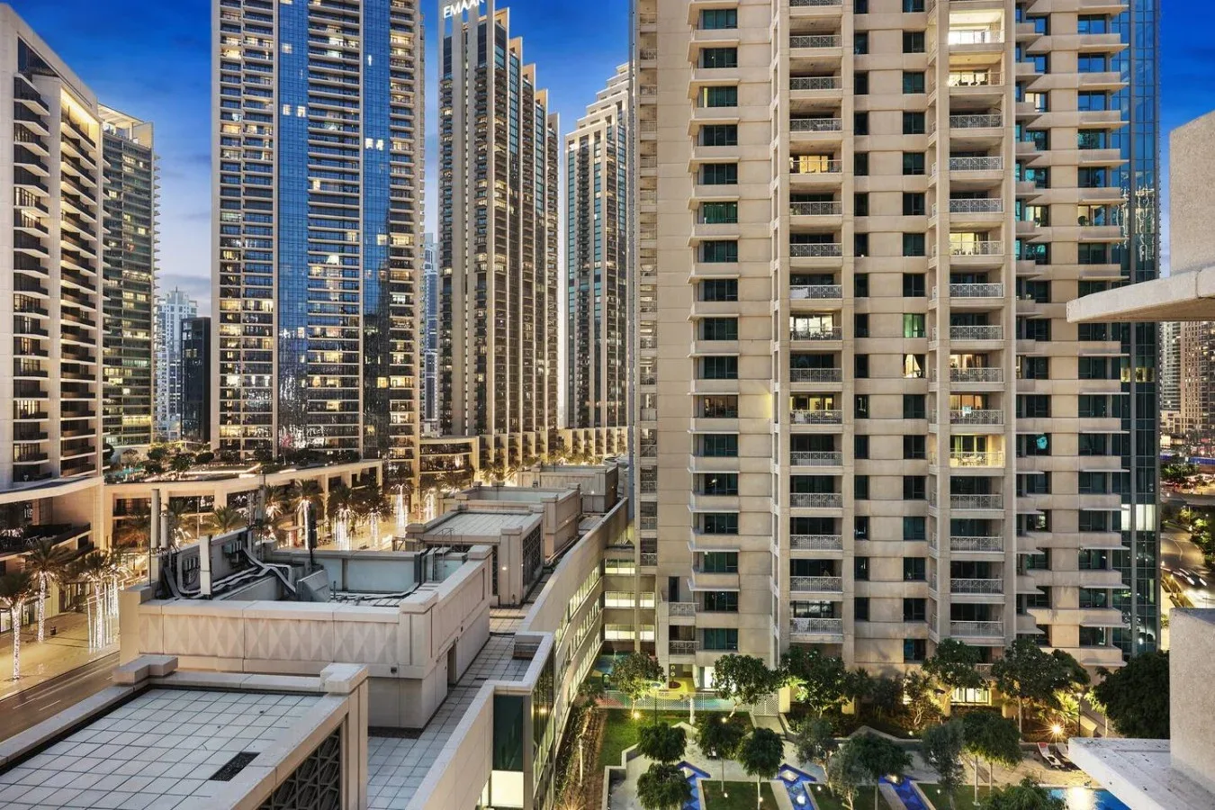 Altos edificios residenciales rodean una terraza en una escena urbana de rascacielos.