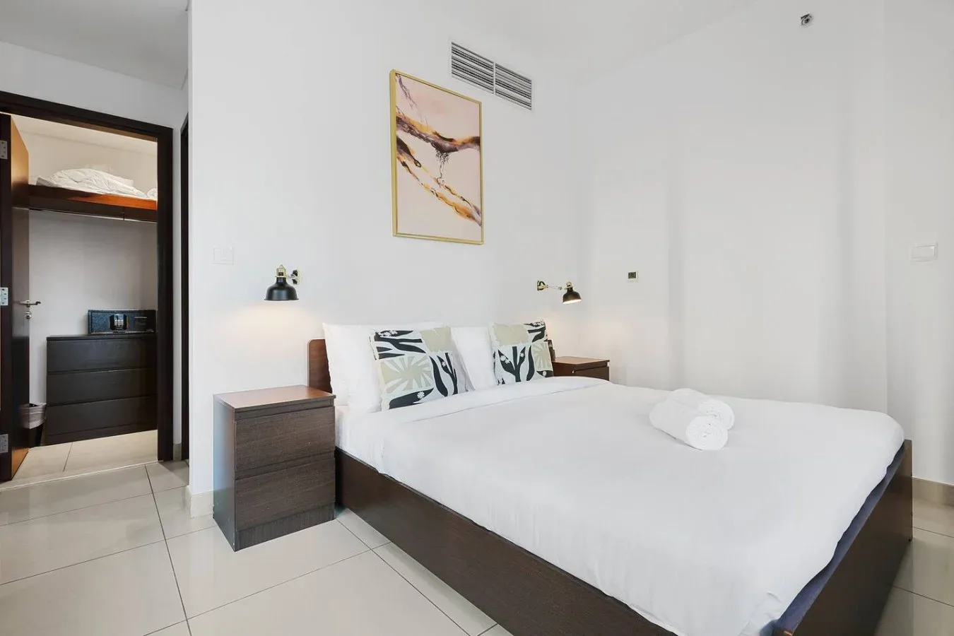 Un dormitorio luminoso con una cama bien tendida y mesitas de noche.
