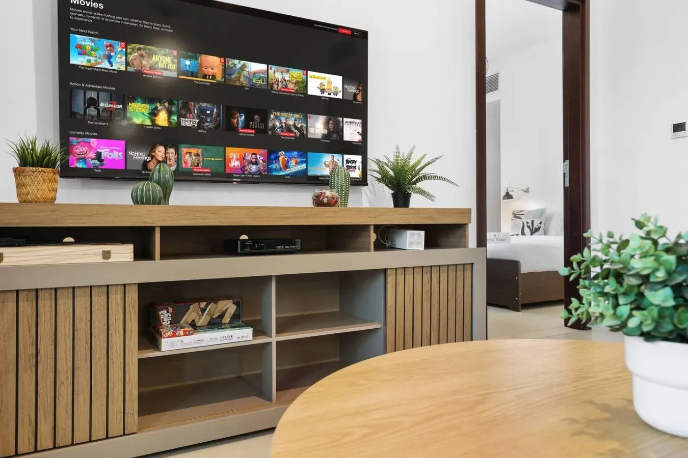 Una sala de estar con un televisor montado en la pared sobre un mueble de madera.