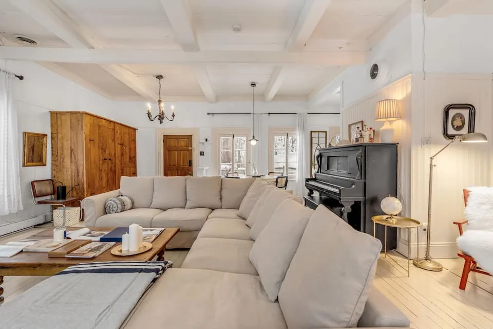 Sala de estar con sofá modular, piano y mueble antiguo