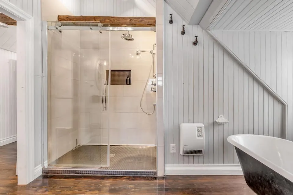 Baño con ducha de cristal y bañera con patas de garra