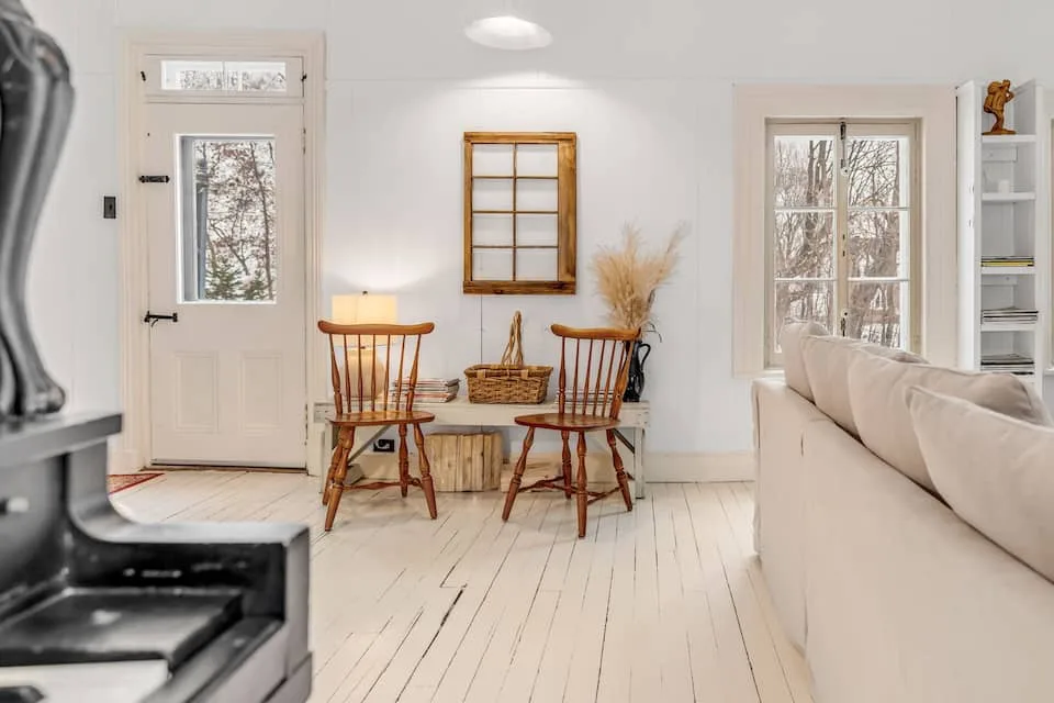Entrada interior luminosa con una mesa pequeña y una puerta de madera
