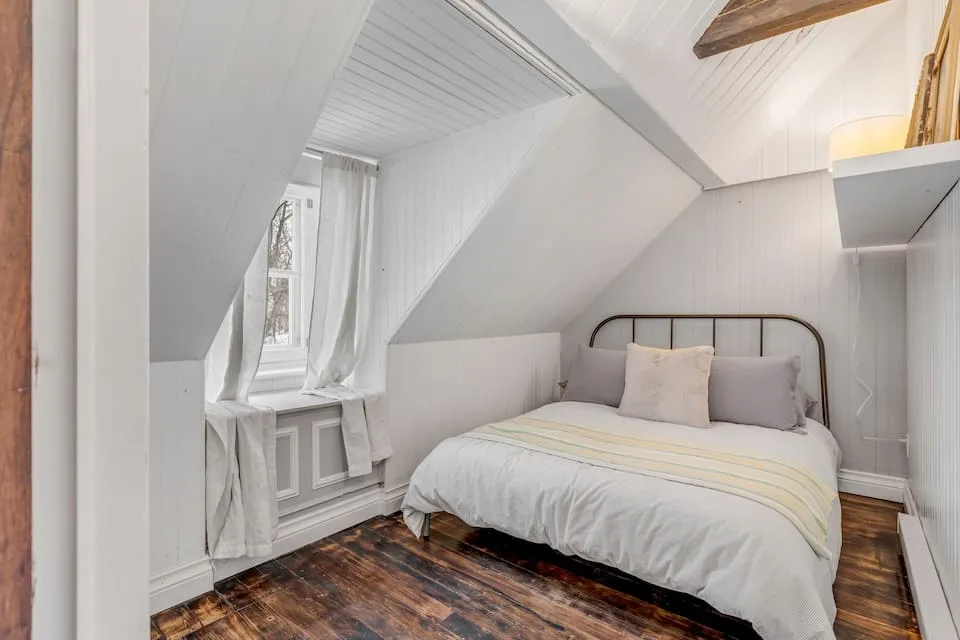 Dormitorio abuhardillado con cama doble