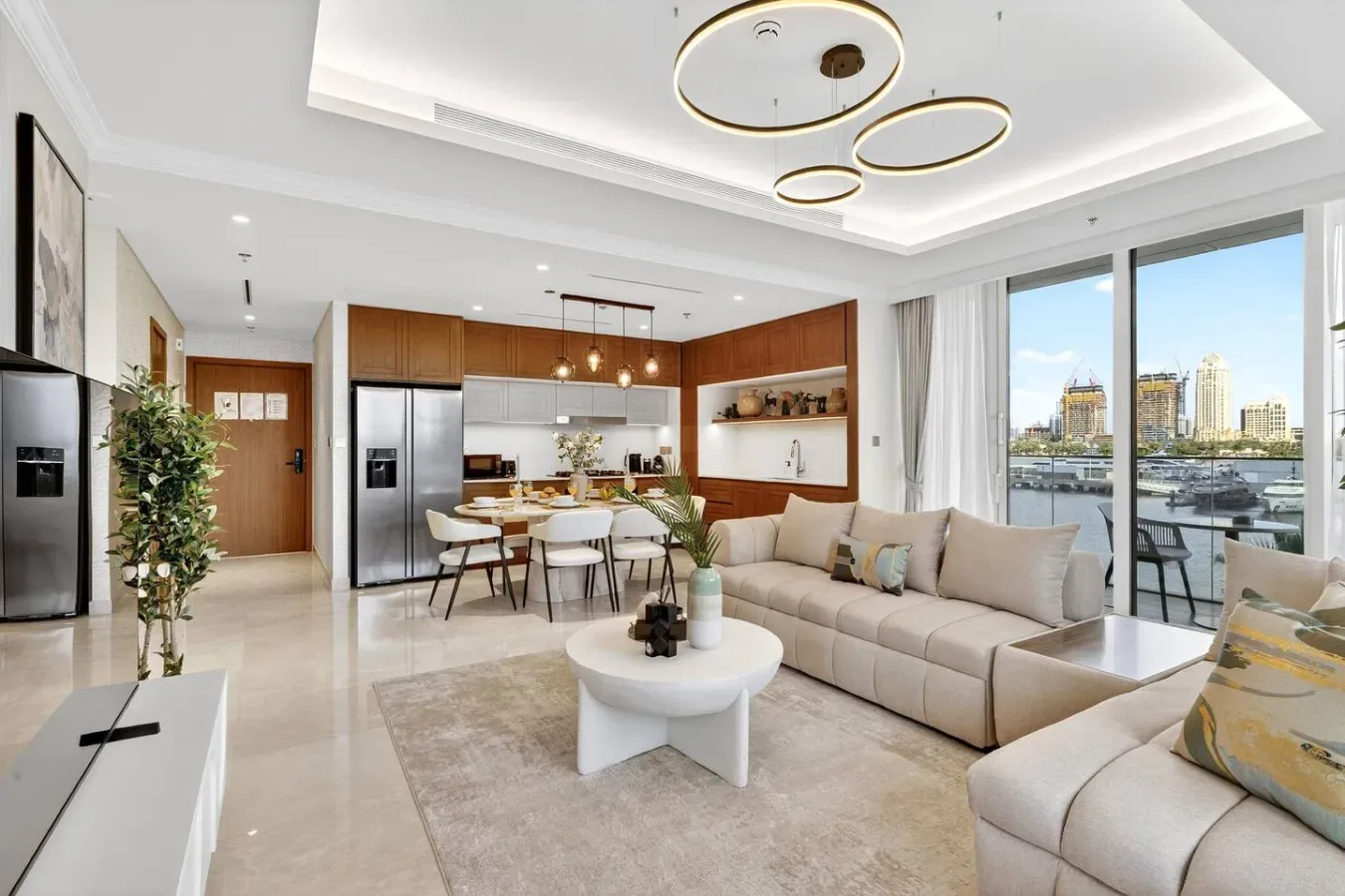 A bright open-plan living room and kitchen opens onto a balcony with city views.