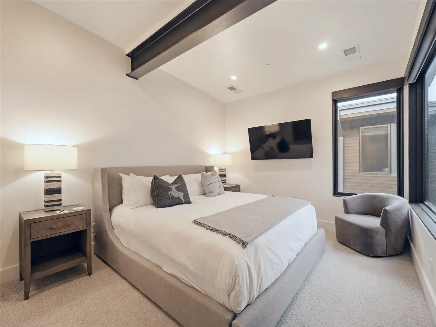 A bedroom with a large bed, bedside tables, and a television.