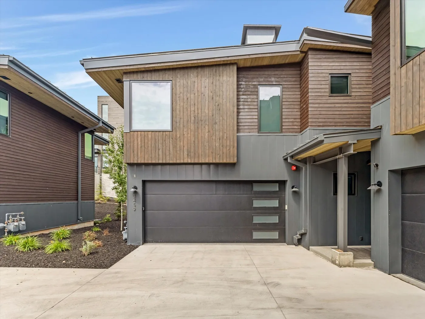 Modern house exterior with a wide driveway and garage.