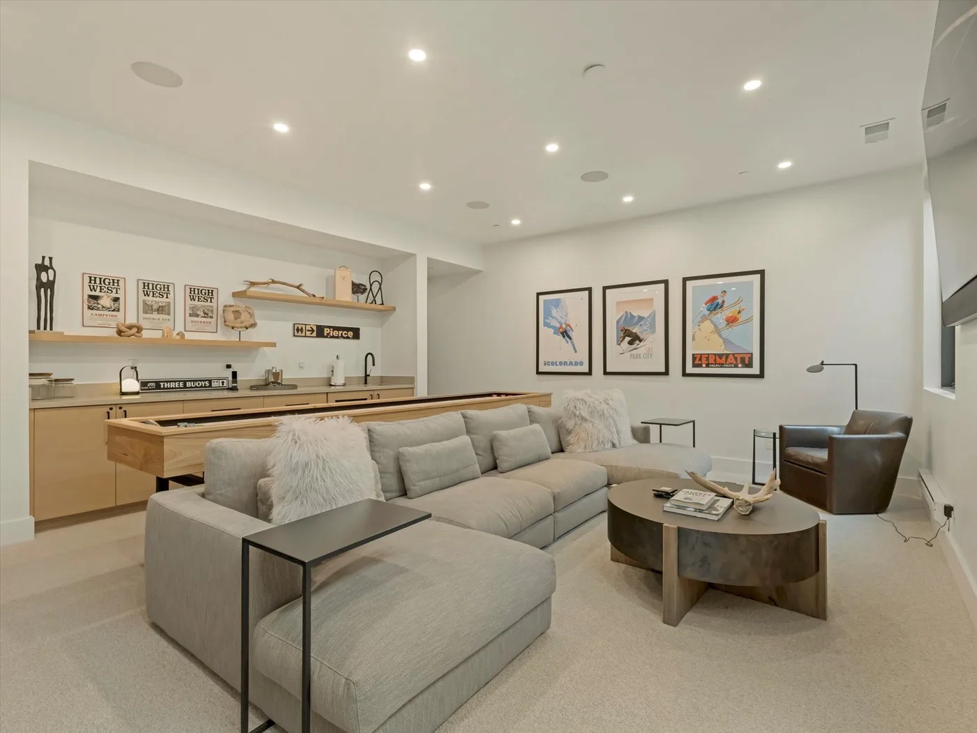 Una sala luminosa con asientos seccionales, una mesa de centro y una pequeña cocina.