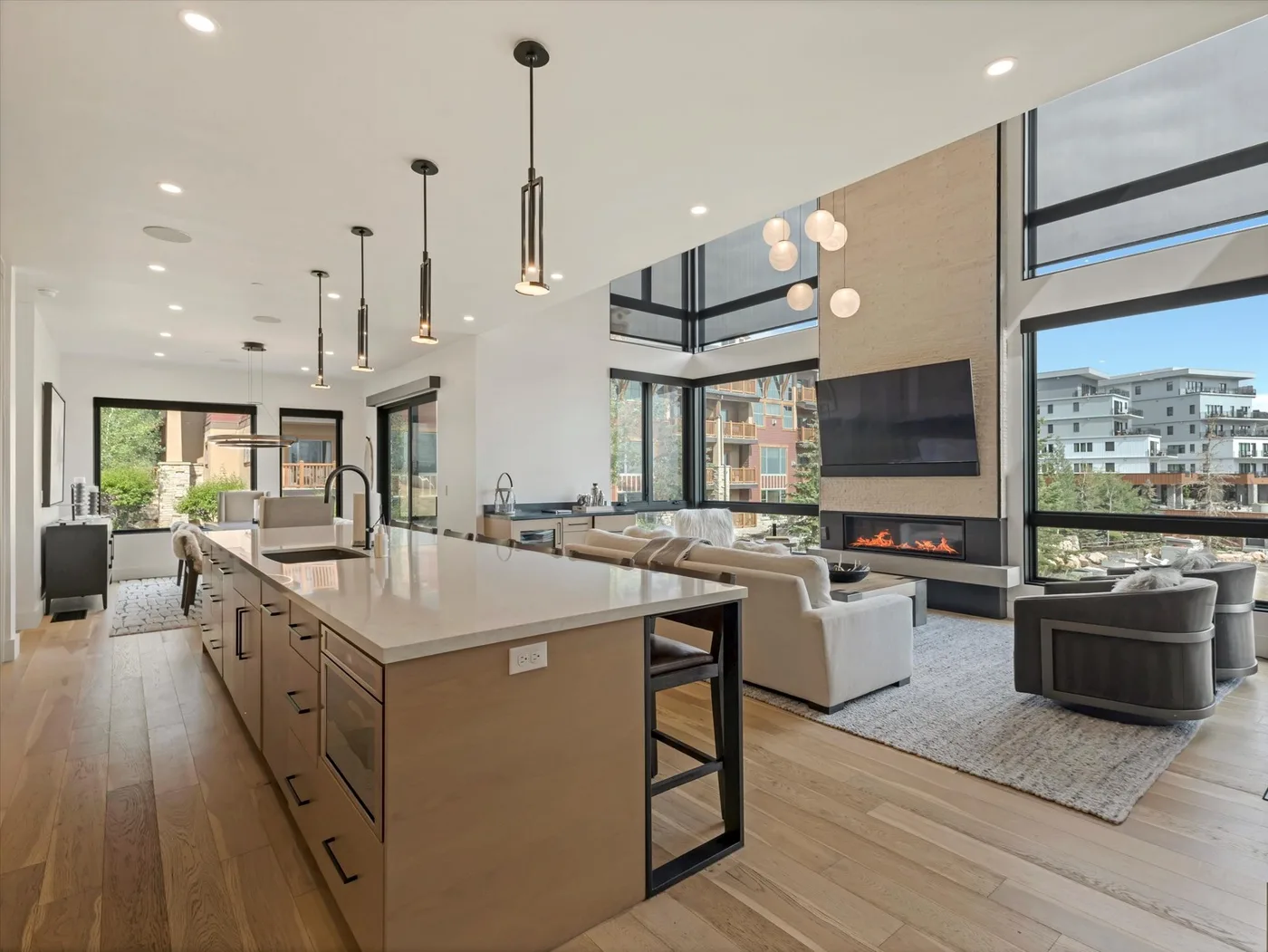 An open-plan kitchen and living area with a long island and large windows.