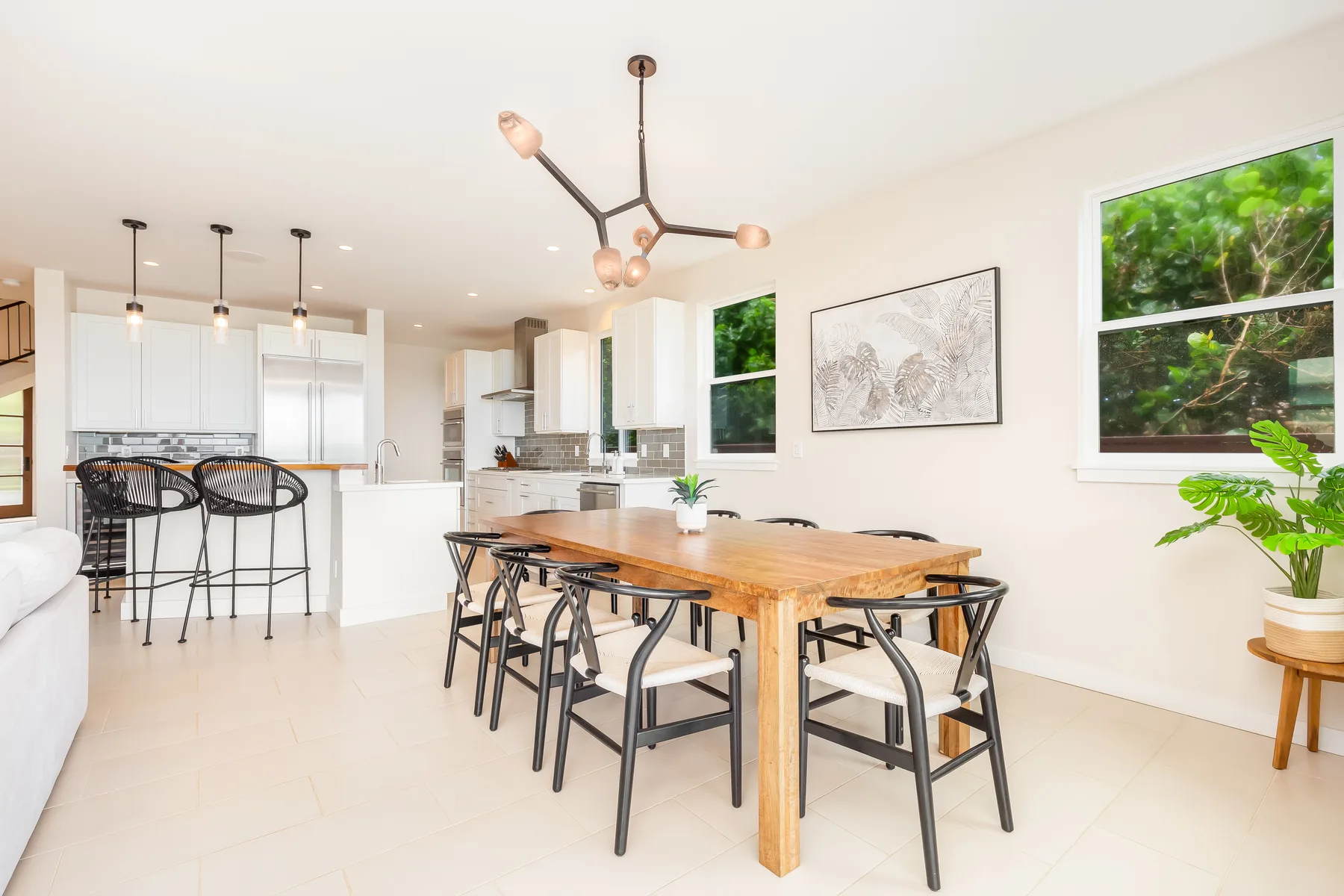 Un comedor luminoso con una mesa de madera junto a una cocina abierta.