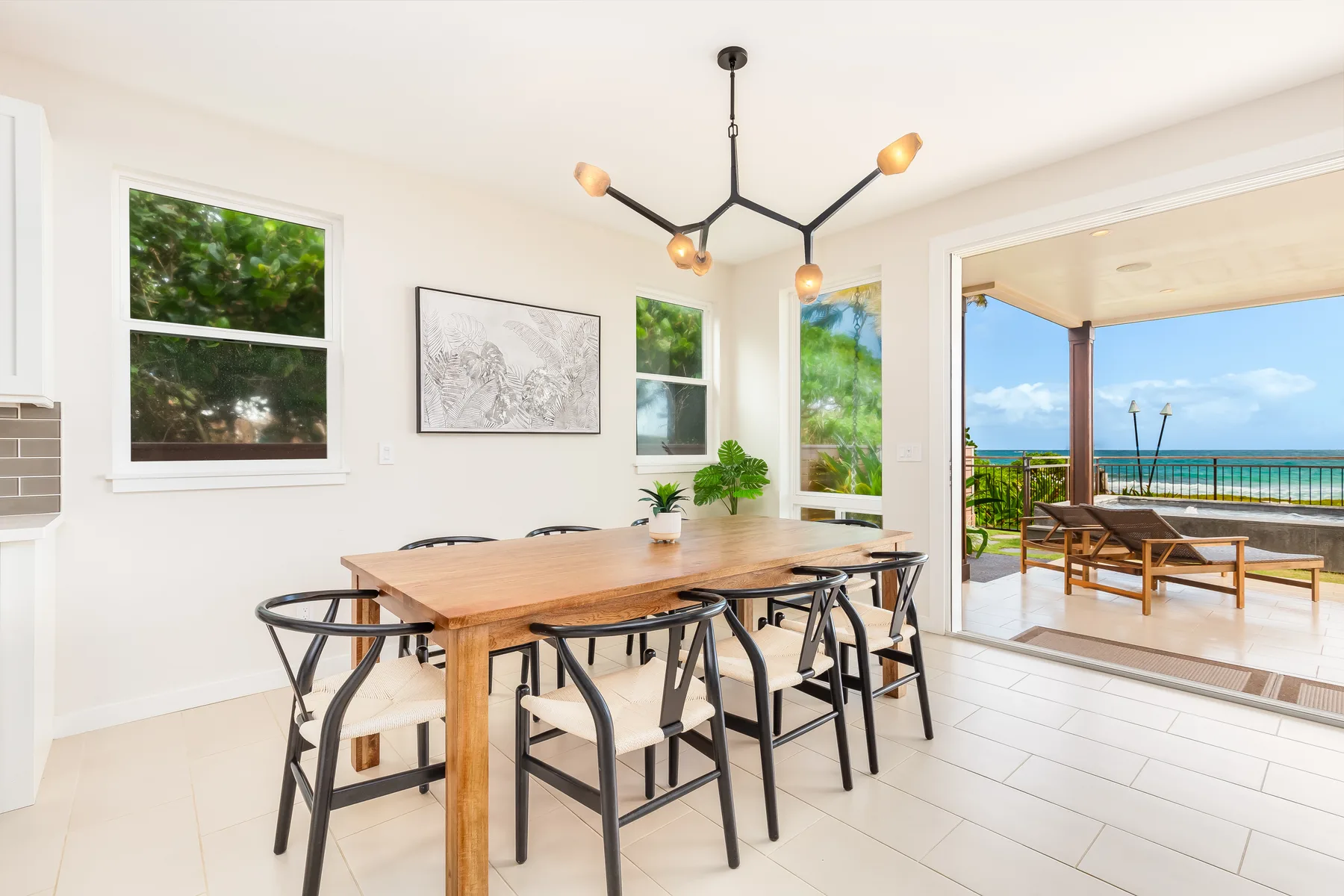 Un comedor luminoso con una mesa de madera y grandes ventanas que dan a un patio.