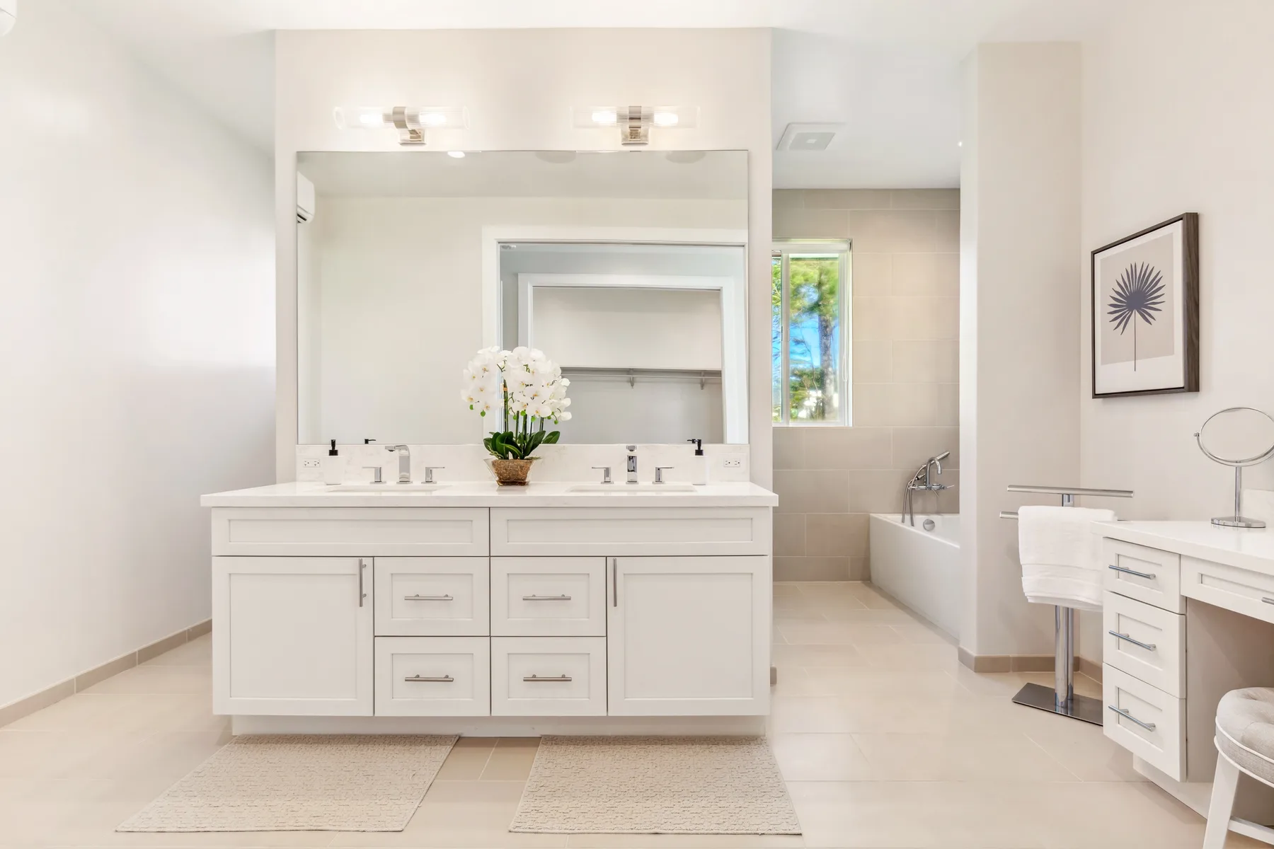 Un baño luminoso cuenta con un lavabo doble y una bañera.