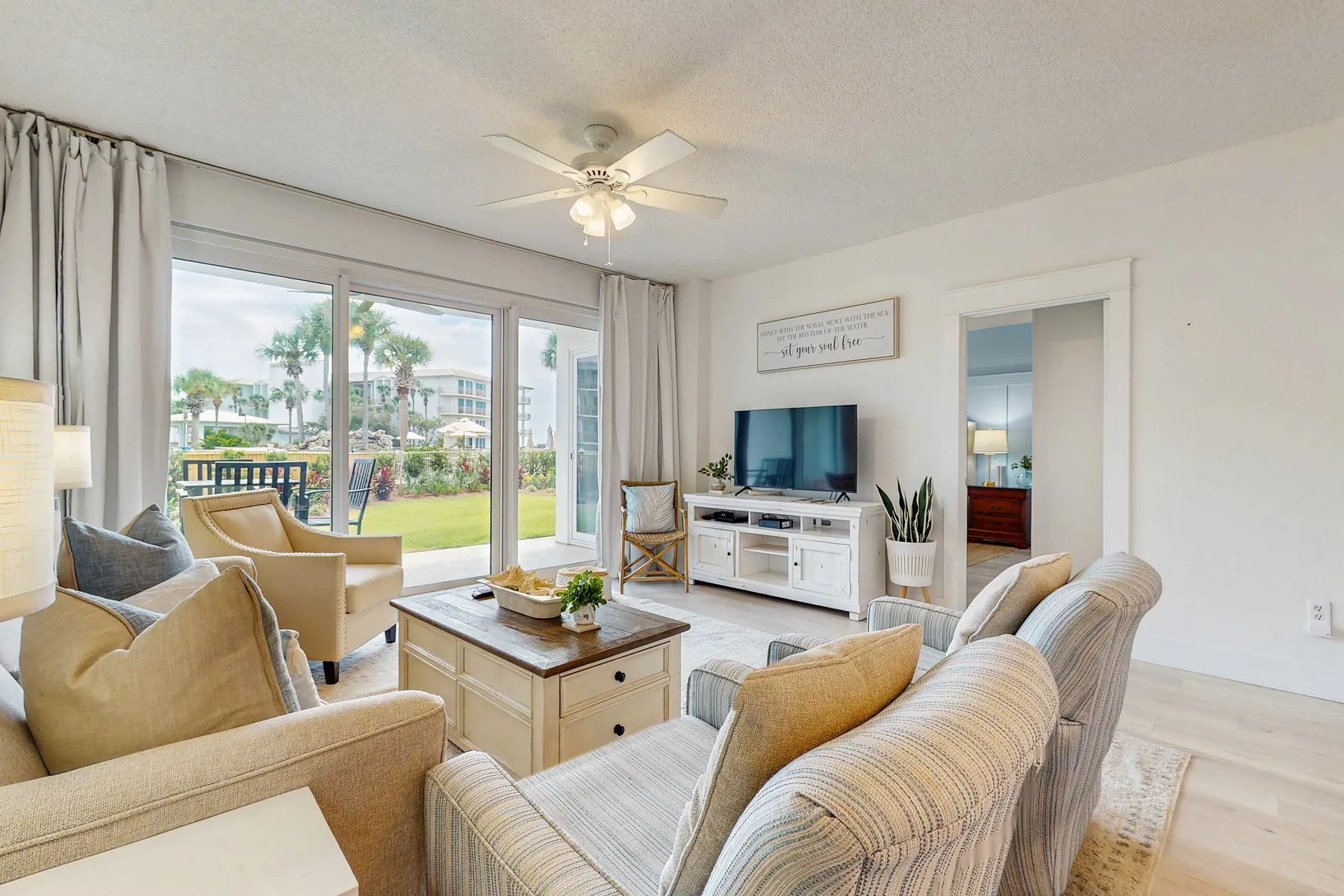 A bright living room with seating arranged around a television and coffee table.