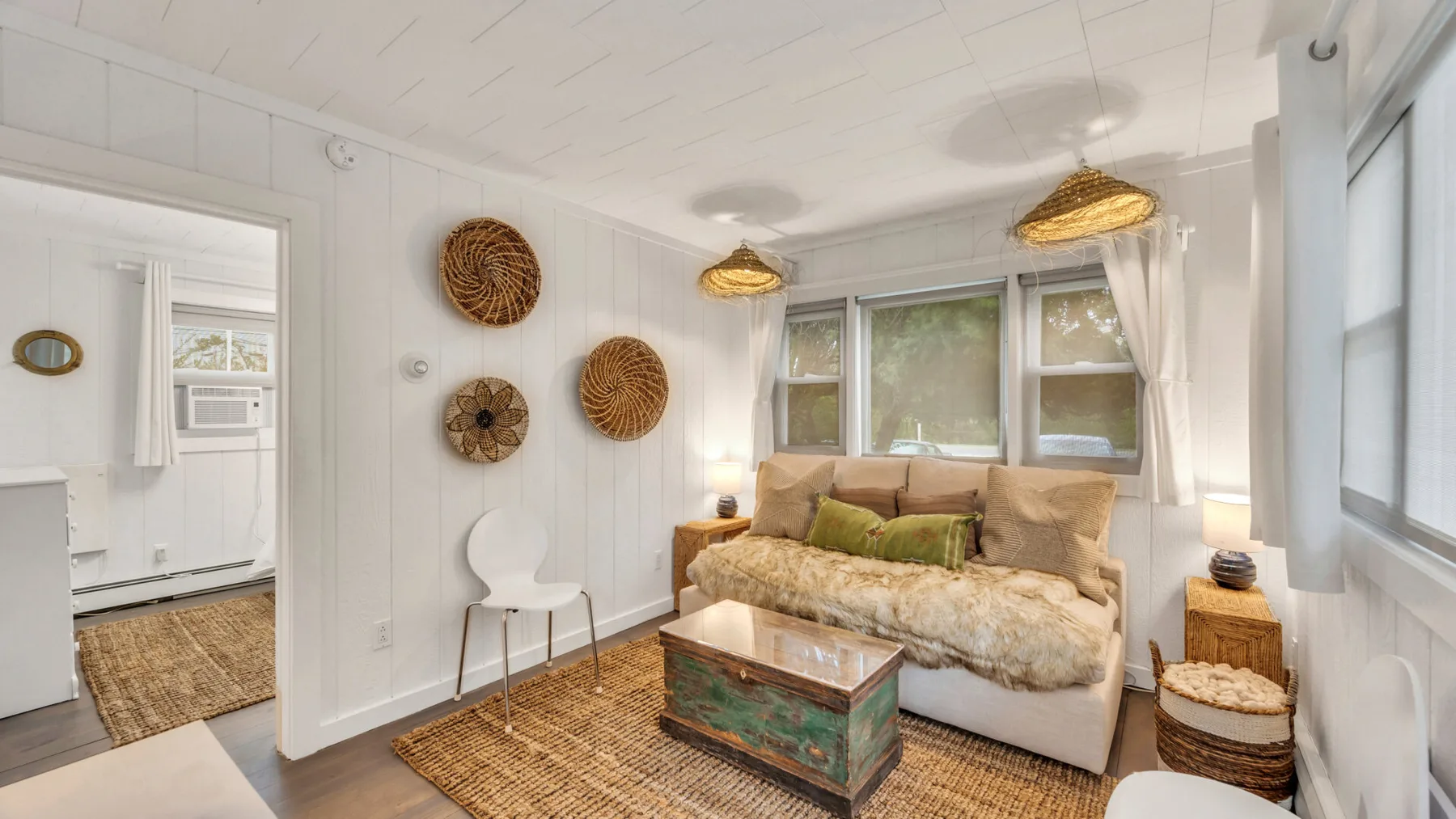 A bright living room with a sofa, woven rug, and coffee table.