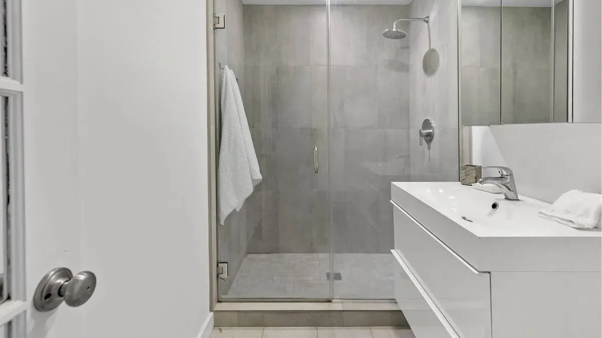 A modern bathroom with a glass shower and a white sink vanity.