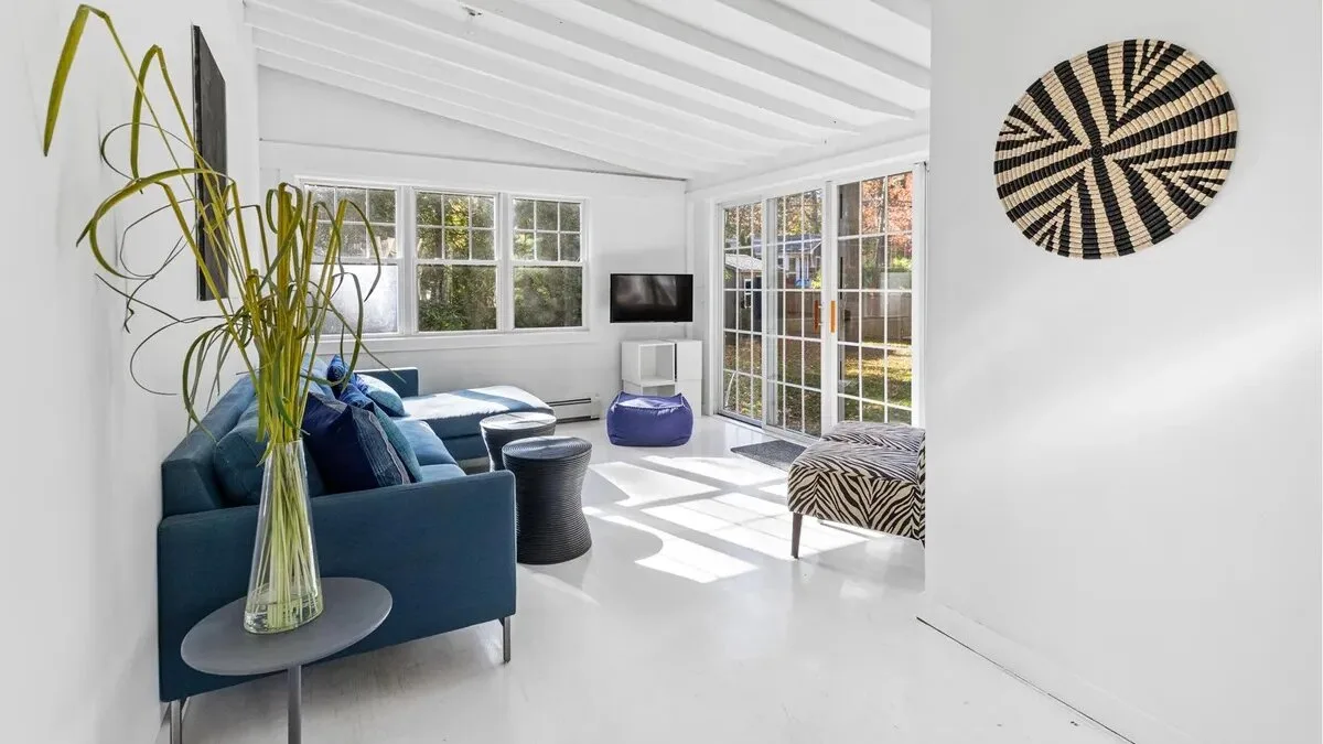 A bright living room with blue seating and large windows.