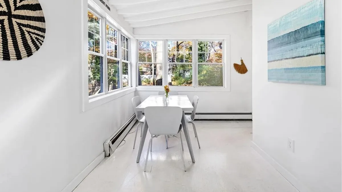 A bright dining area with a table and large windows.