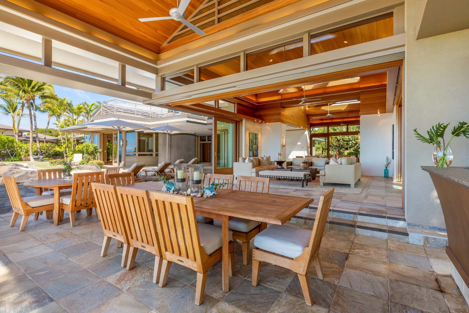 Una zona abierta de comedor y estar con mesas de madera y asientos.