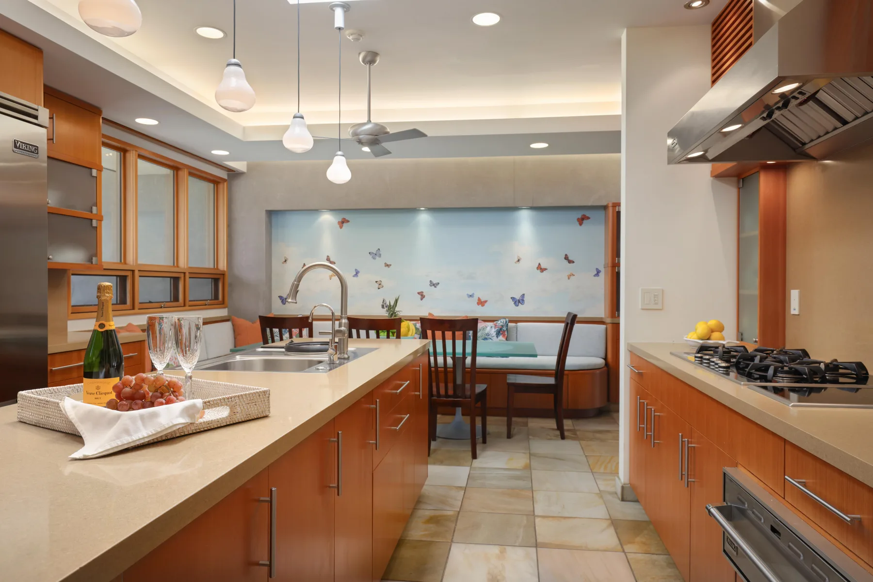 Una cocina con una isla central y una mesa de comedor frente a un mural colorido.