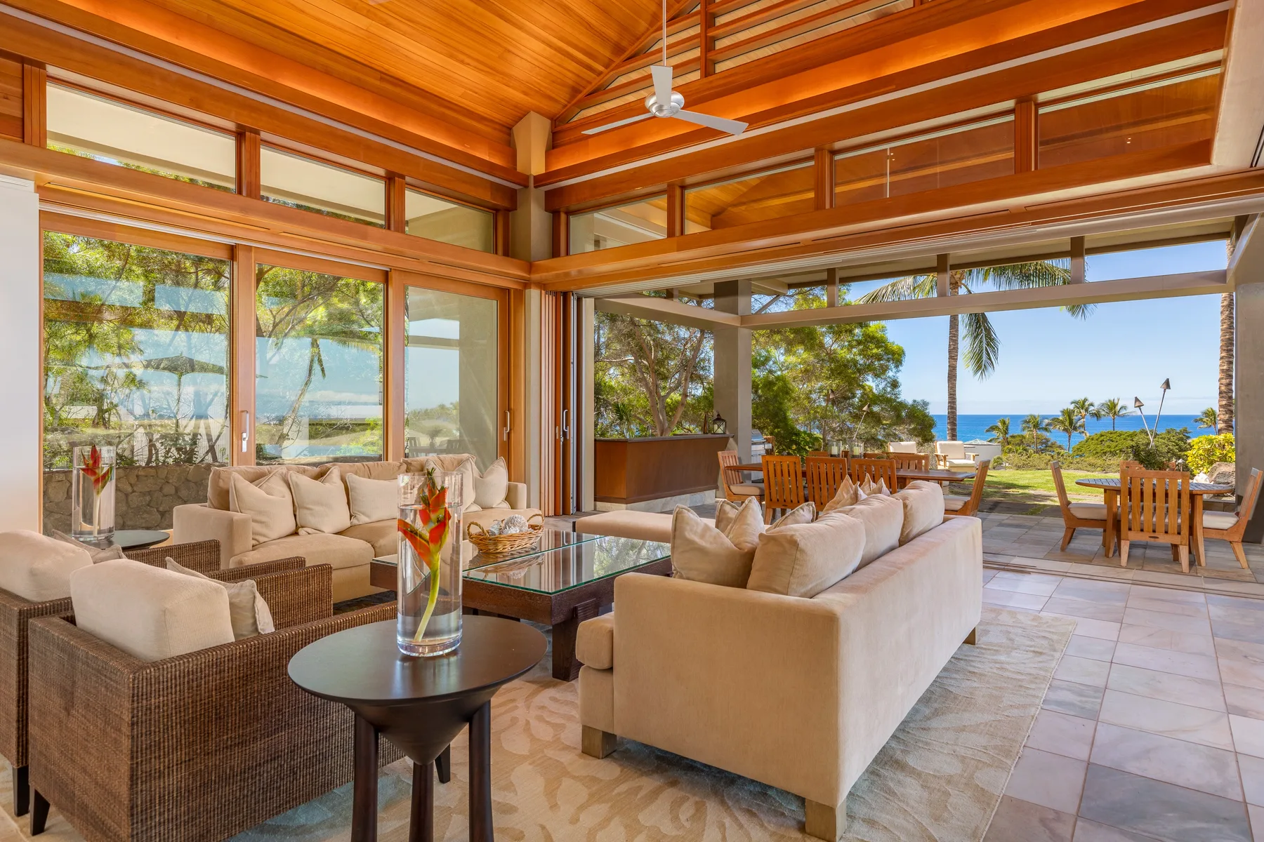 Una amplia sala de estar se abre a un comedor exterior con vistas al mar.