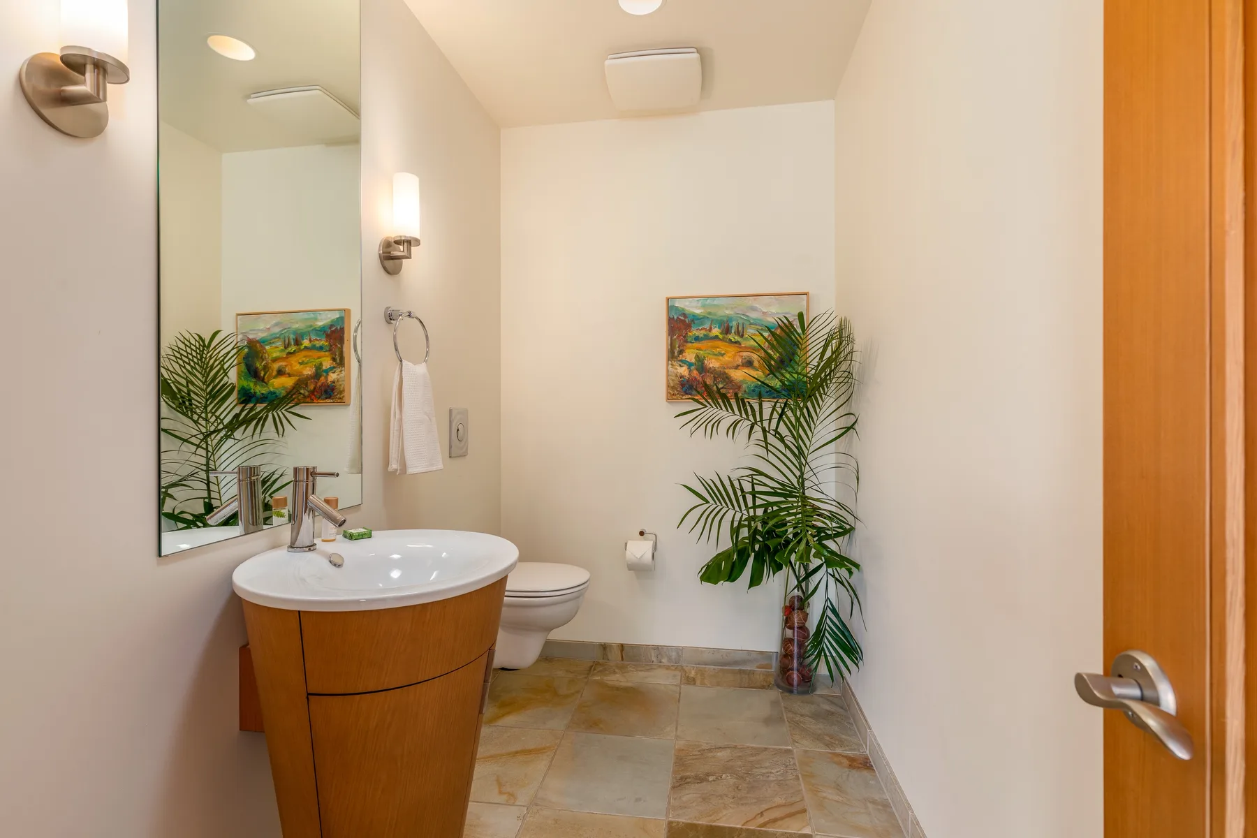 Un baño con lavabo, inodoro y una planta en maceta.