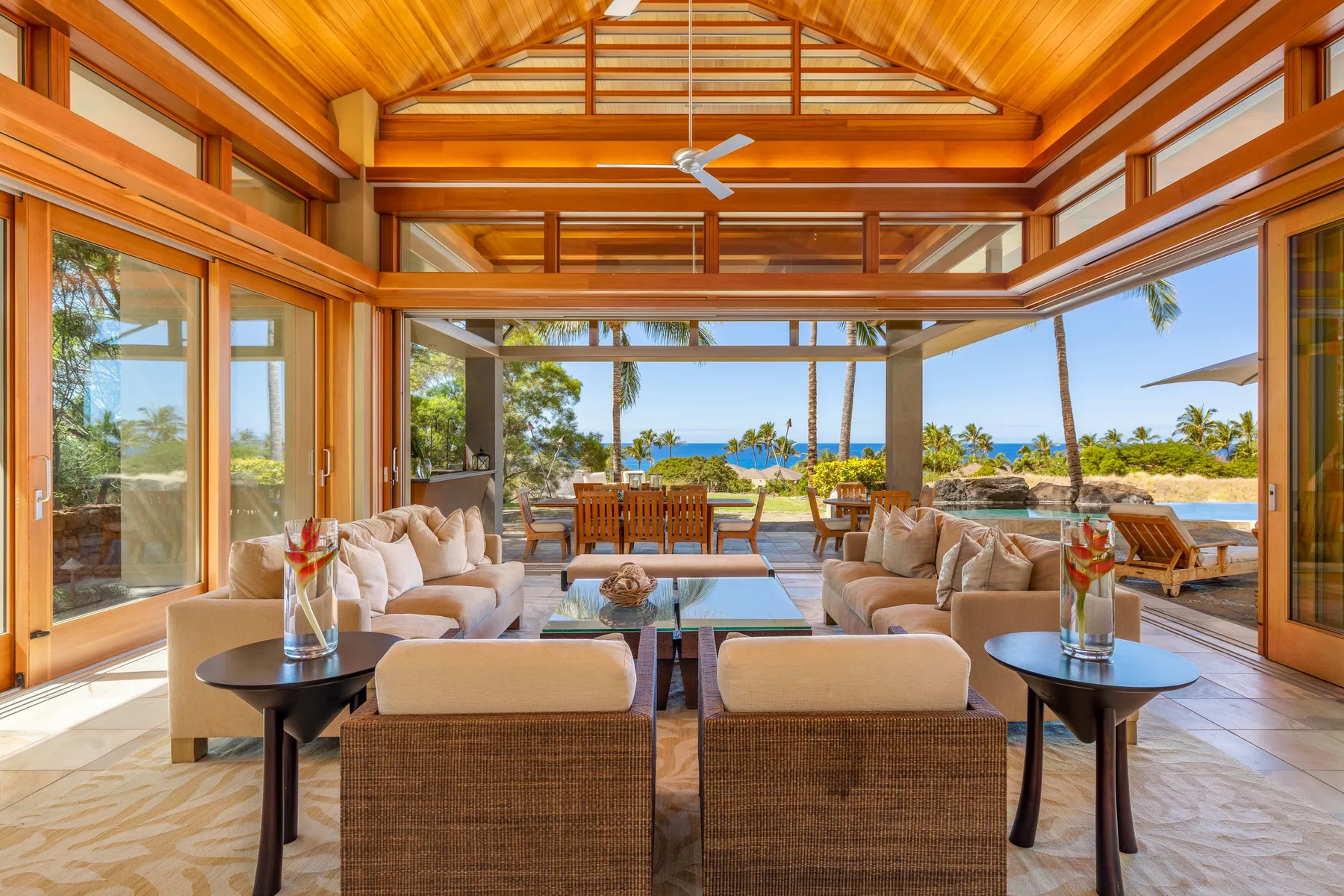 An open living area faces the ocean, with seating and a dining table.