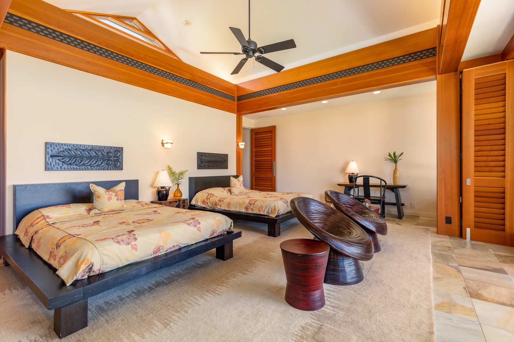 Un dormitorio con dos camas, vigas decorativas de madera y una mesa pequeña.