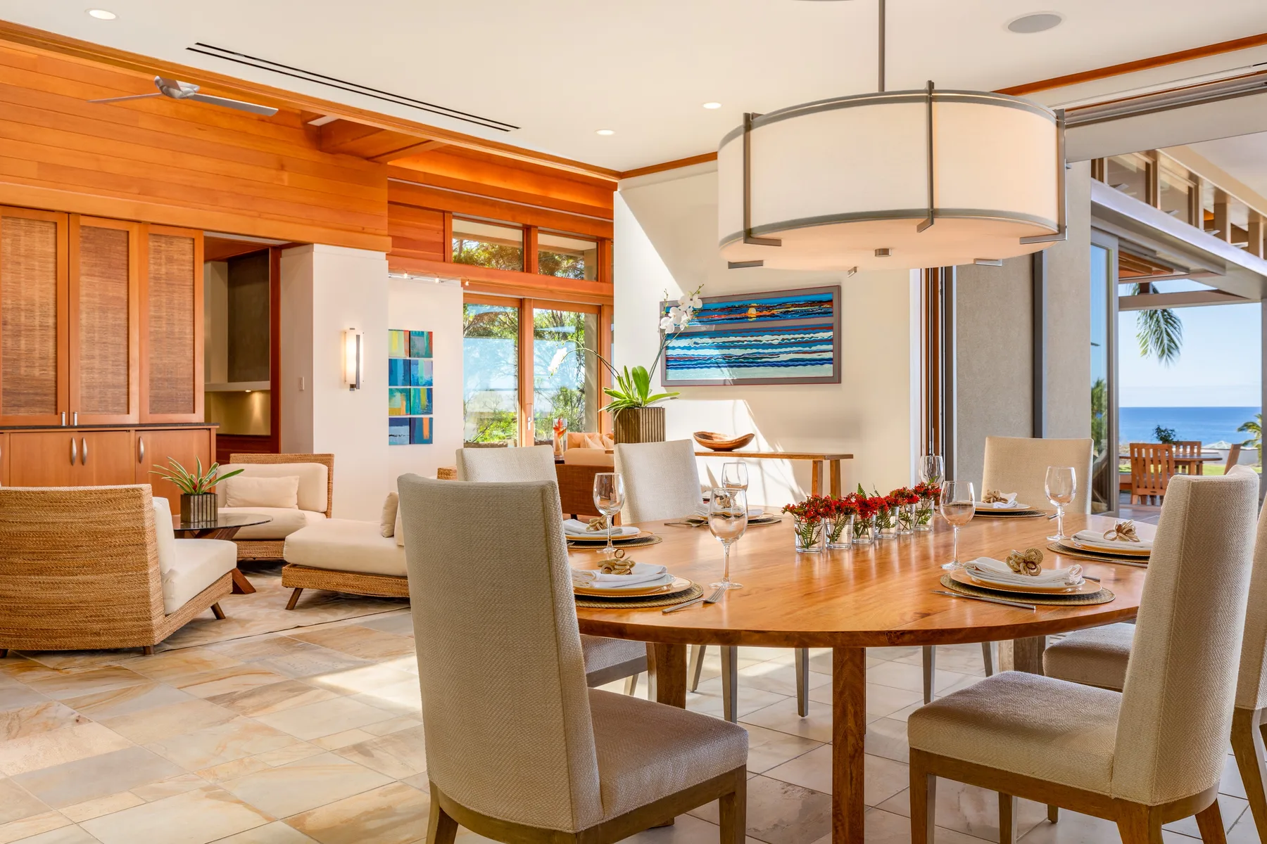 Un comedor luminoso con la mesa puesta y asientos junto a grandes ventanales.