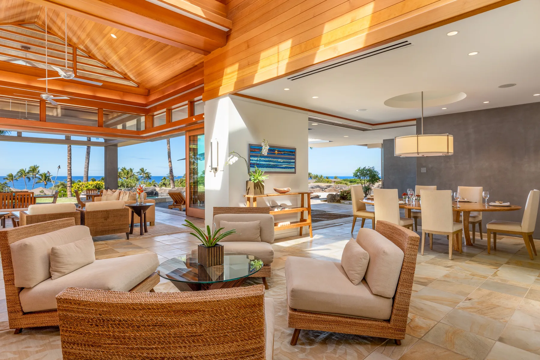 Una sala abierta con comedor, asientos y vistas al mar.