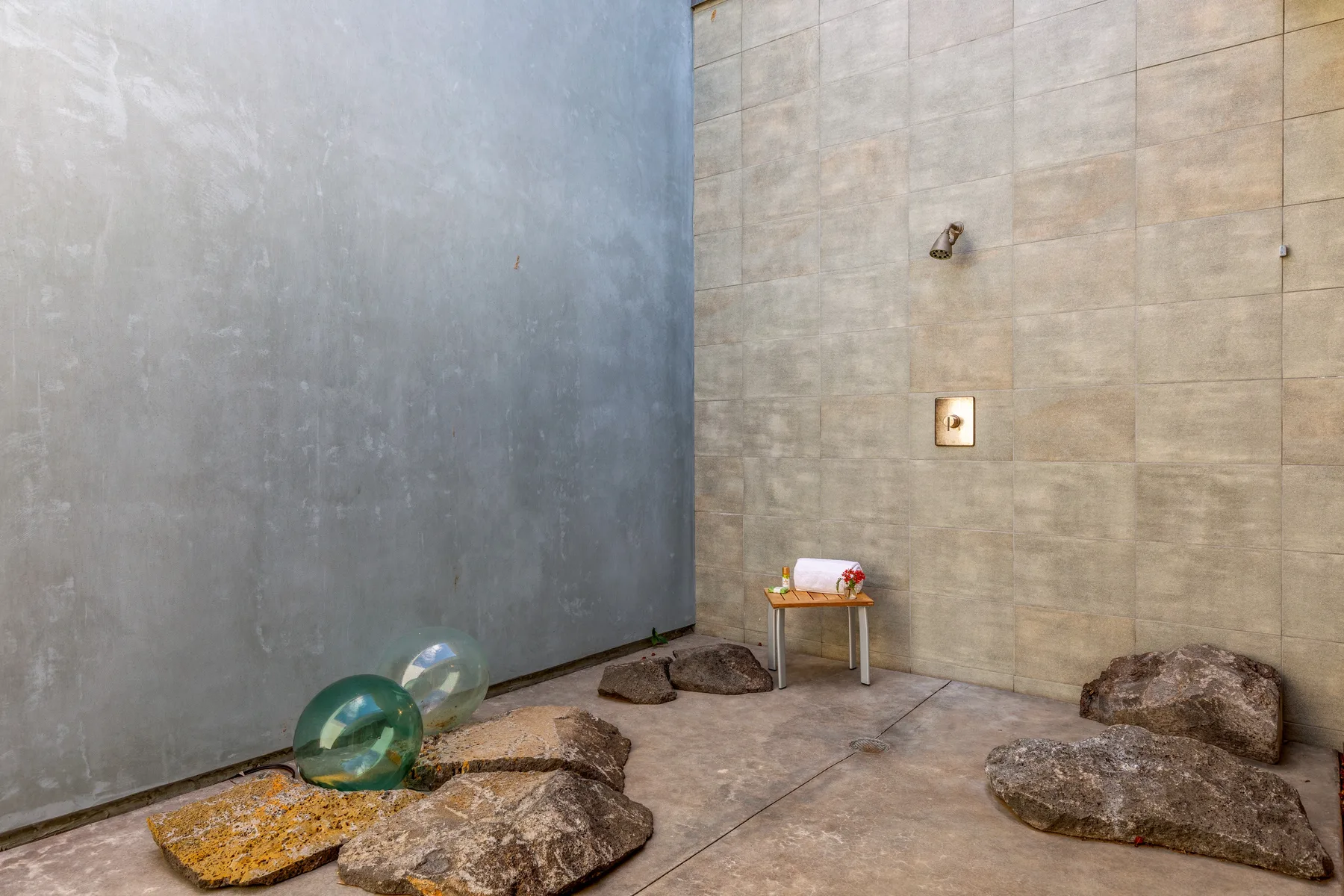 Un espacio interior con paredes de azulejos, superficies de piedra y un pequeño taburete junto a la pared.
