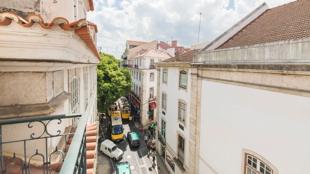 Una calle estrecha entre edificios, vista desde un balcón.
