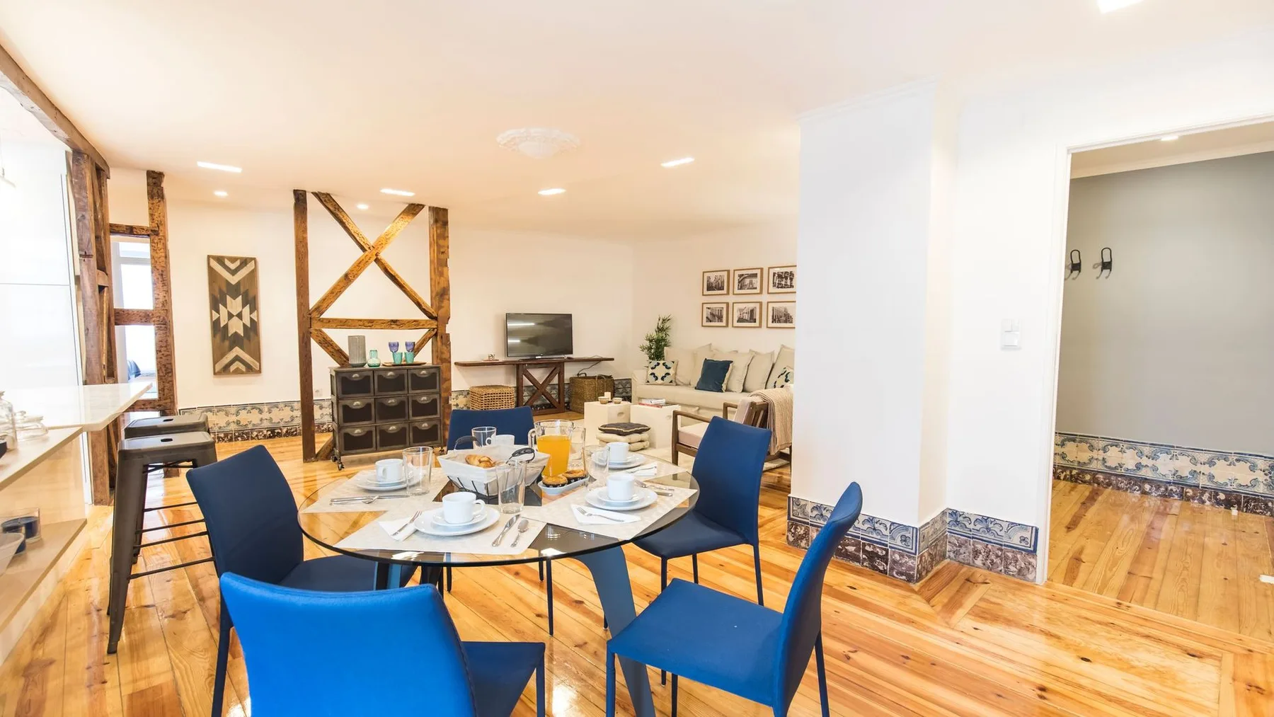 Comedor con una mesa puesta y asientos azules.
