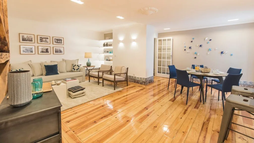 A bright living and dining room with seating around a table.