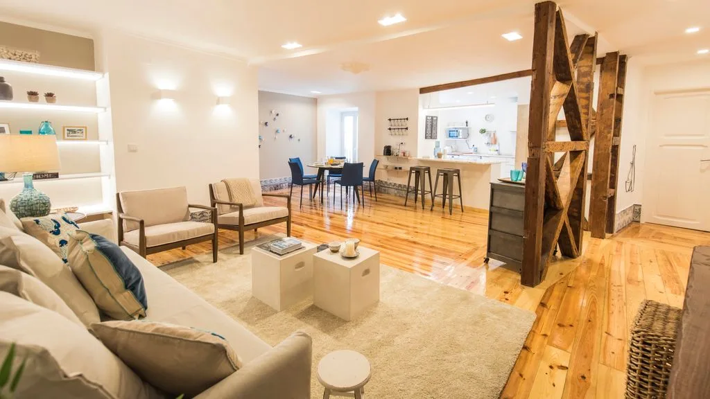 Una luminosa sala de estar y comedor diáfana con una barra de cocina.