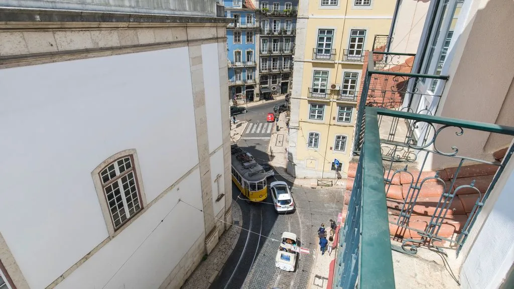 Vista de una calle desde un balcón, con edificios y tráfico.