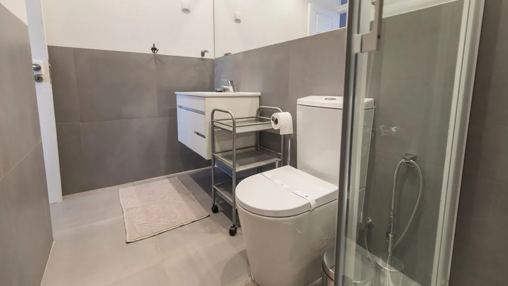Un baño con lavabo, inodoro y ducha de cristal.