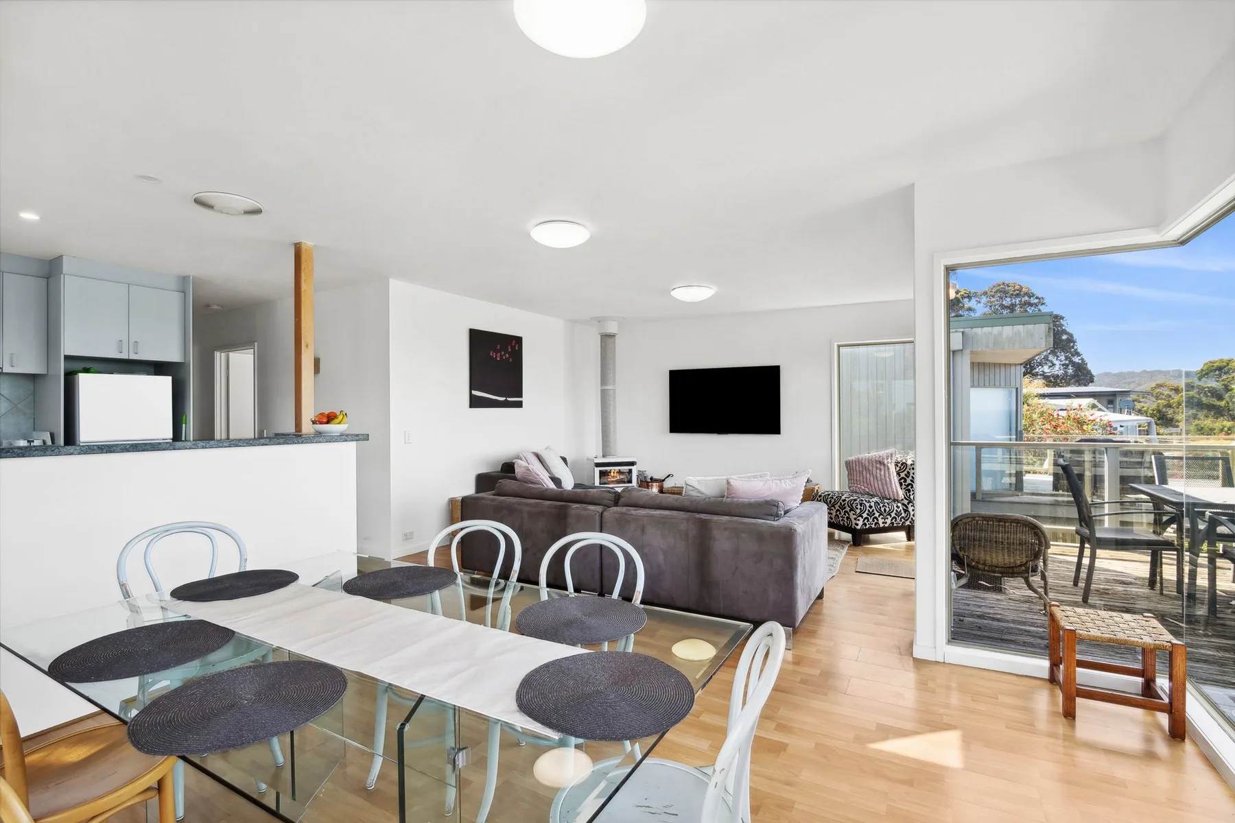 Sala y comedor de planta abierta con una barra de cocina y puertas corredizas de vidrio.